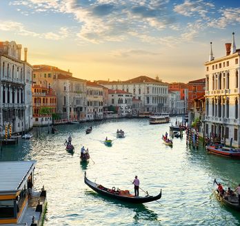 Eine Luftaufnahme von Venedig, Italien, mit Kanälen und Gebäuden bei Sonnenuntergang.