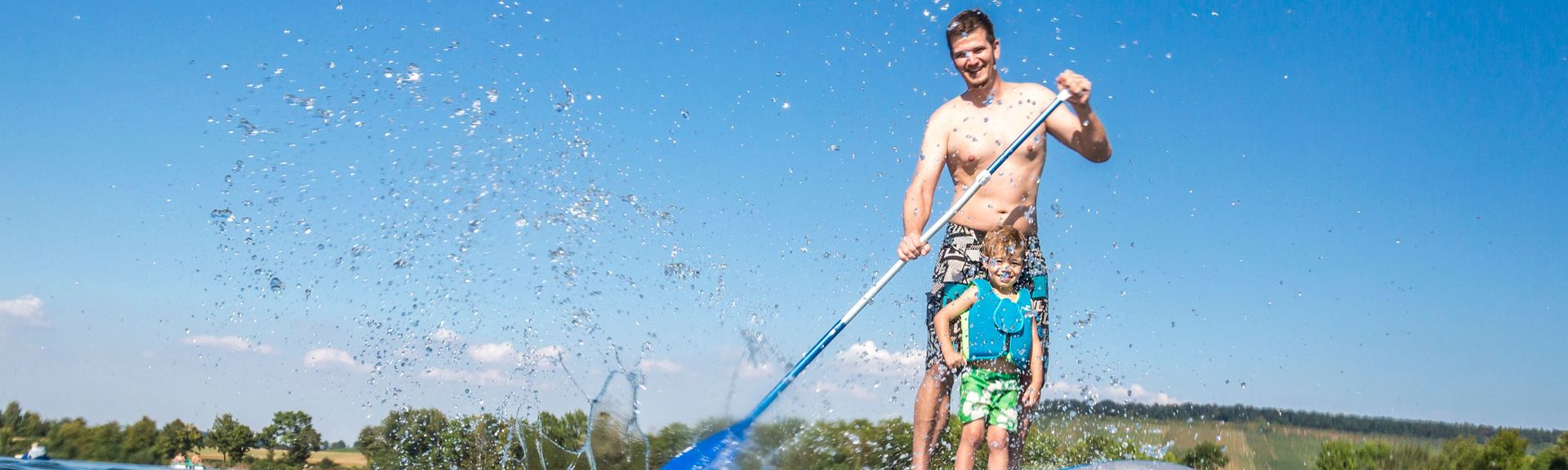 VAter und Sohn beim Standuppaddeln auf einem See