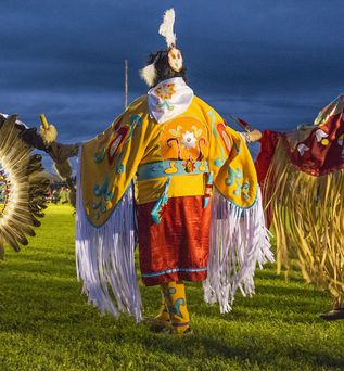 Traditionell gekleidete Ureinwohner mit bunten Gewändern und Federn 