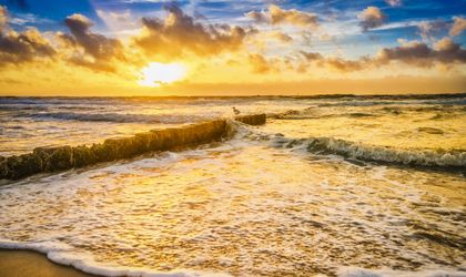 Strand mit Wellen bei Sonnenuntergang.