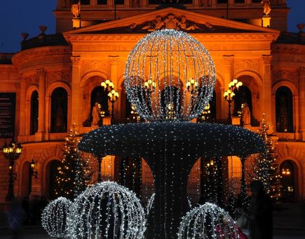 Das Opernhaus in Frankfurt, Deutschland, mit einem beleuchteten Brunnen.
