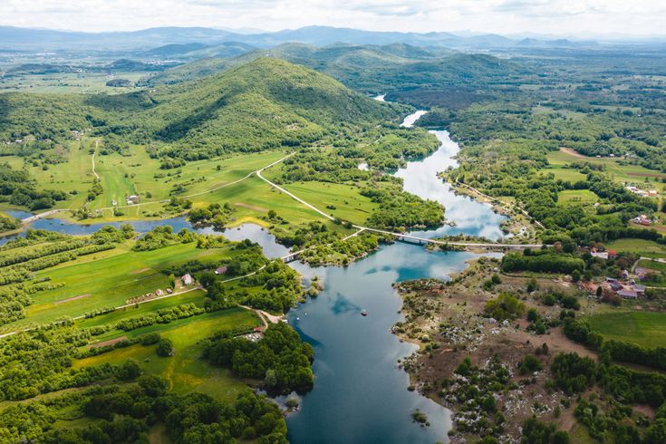 Eine Luftaufnahme eines Flusses, der sich durch eine grüne Landschaft schlängelt.
