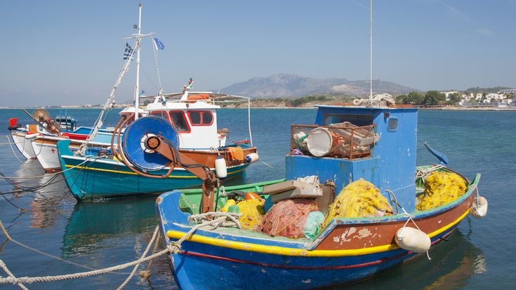 Fischerboote in der Bucht von Mastichari, blauer Himmel.