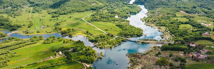 Eine Luftaufnahme eines Flusses, der sich durch eine grüne Landschaft schlängelt.