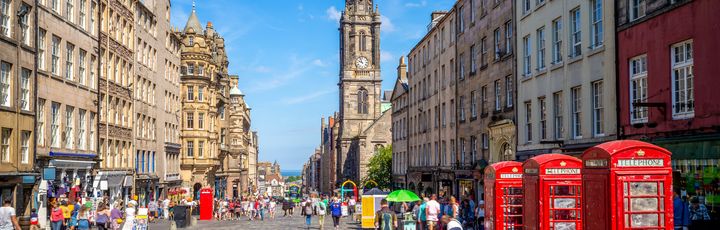 Blick auf die Royal Mile mit seinen roten Telefonzellen und imposanten Gebäuden.