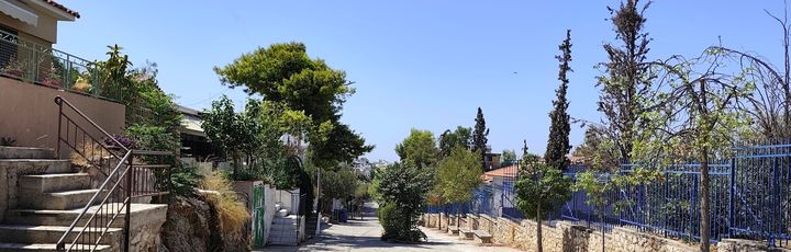 Blick über ein Gässchen in Petralona, links und rechts Wohnhäuser.