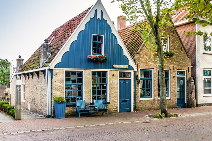 Ein blaues Haus mit einem Garten und einem Zaun.