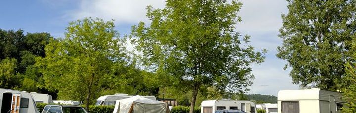 Ein Campingplatz mit Wohnmobilen und Bäumen.