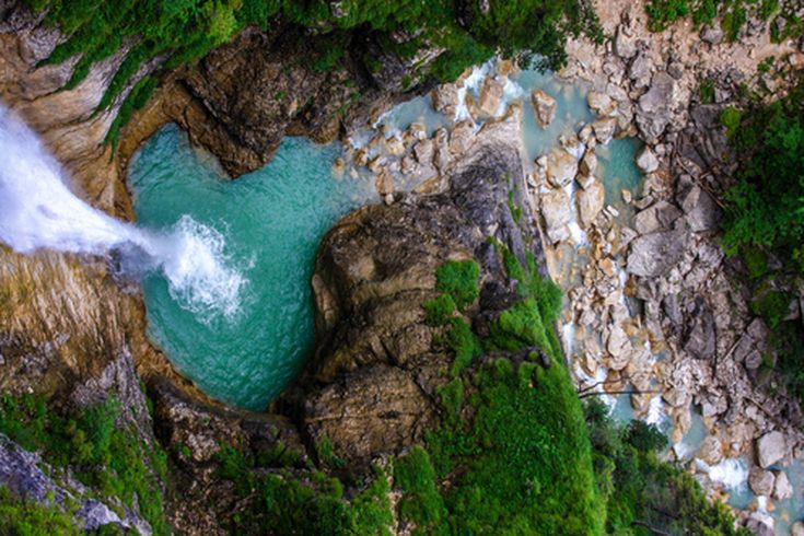 Eine Landschaft mit einem Wasserfall und einem Fluss.