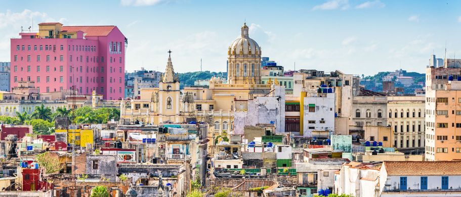 Eine Stadtansicht von Havanna mit bunten Gebäuden und dem Meer.
