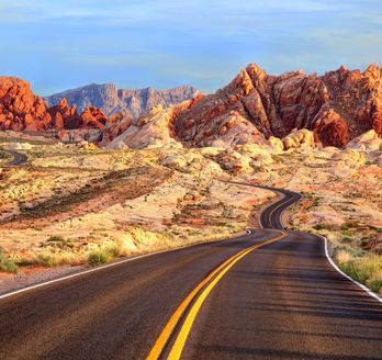 Straße zwischen rot-braunen Felsen in USA