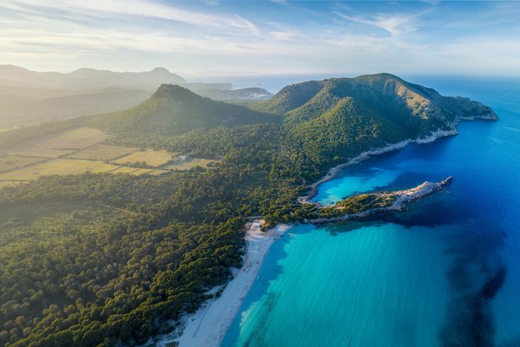 Blick über die Bucht Cala Agulla mit seinem saftig grünem Hinterland.