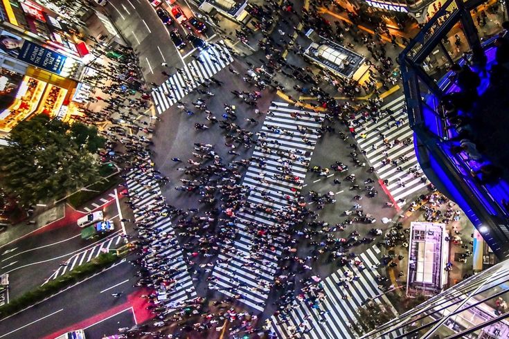 Shibuya-Kreuzung aus der Vogelperspektive bei Nacht – Die ikonische Shibuya-Kreuzung in Tokio wirkt aus der Höhe wie ein bewegtes Kunstwerk aus Menschenströmen.