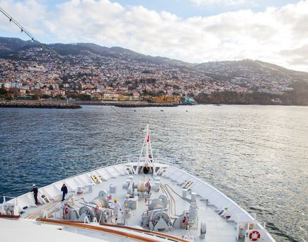 Ausblick von vorne aus dem MS Hamburg Kreuzfahrtschiff auf eine Hafenstadt in Portugal
