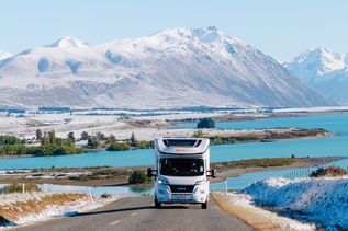 Camper fährt auf Straße am Lake Tecapo in Neuseeland