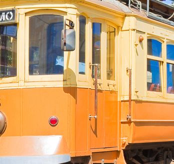 Eine gelbe Straßenbahn in einer Stadt.