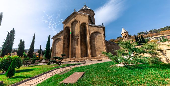 Morgendlicher Blick auf die Stadt Mzcheta und die Kathedrale von Svetitskhoveli. Sonnenlicht auf den Bergen. Zusammenfluss der Flüsse Aragvi und Kura