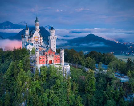 Eine Stadtansicht mit einem Schloss und einem Fluss.