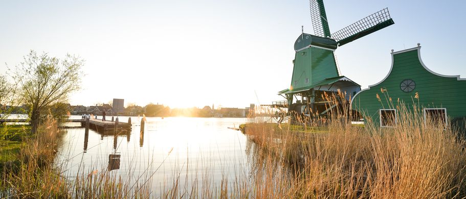 Romantische Abendstimmung am See mit Blick auf die traditionellen Mühlen in Zaanse Schans