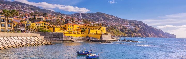 Eine Hafenstadt mit bunten Gebäuden und einem Schiff.
