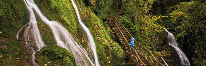 Ein Wasserfall, der in mehrere Stufen über Felsen fließt.