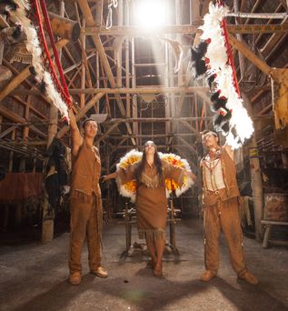 Traditionell indianisch gekleidete Ureinwohner in einer Holzscheune