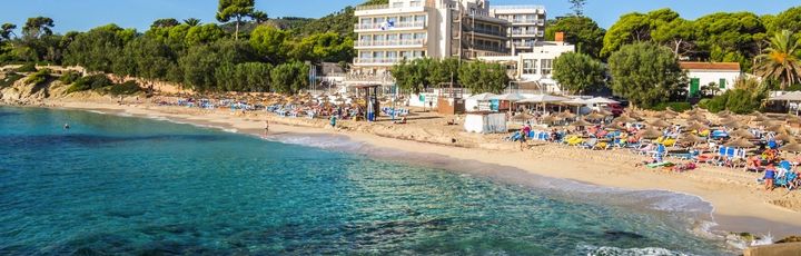 Eine Bucht mit einem Strand und türkisfarbenem Wasser.