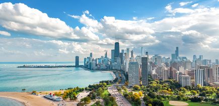 Luftaufnahme der Skyline von Chicago aus der Vogelperspektive, Blick auf den Michigansee und die Wolkenkratzer der Innenstadt von Chicago aus dem Lincoln Park, Illinois, USA. Das alles bei strahlend blauem Himmel.