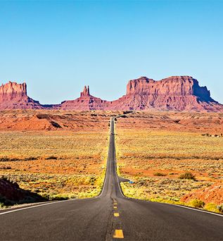 Weitläufiger Blick auf die Route 66 mit Bergen im Hintergrund