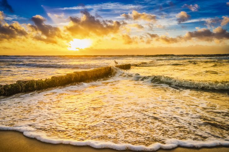 Strand mit Wellen bei Sonnenuntergang.