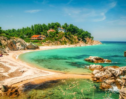 Eine Bucht mit türkisblauem Wasser und einem Strand.