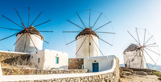 Eine weiße Stadt mit Windmühlen auf einer griechischen Insel.
