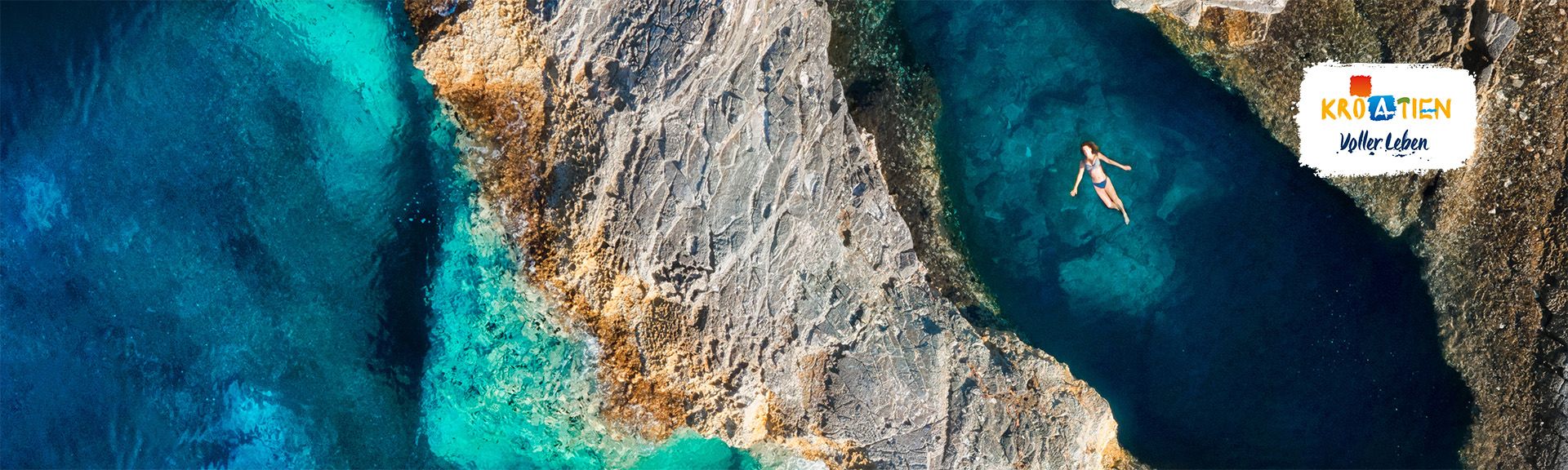Eine Frau liegt im Wasser eines Naturpools umgeben von Felsen