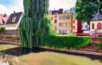 Ein Gebäude am Wasser mit einer Brücke und einem Park.