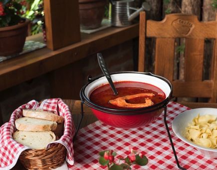 Ein Topf mit Fischsuppe auf einem Holztisch.