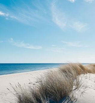 Ein Sandstrand mit türkisfarbenem Wasser.