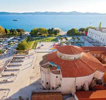 Eine Luftaufnahme der Altstadt von Zadar, Kroatien, mit roten Dächern und dem Meer.