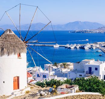 Blick über den Hafen von Mykonos im Vordergrund die berühmten Windmühlen
