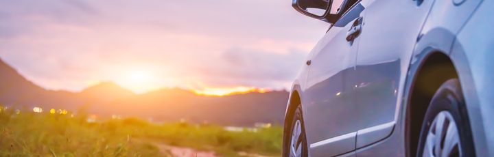 Hinteres Profil vom Auto mit Sonnenuntergang im Fokus