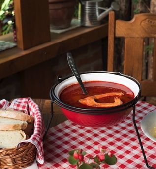 Ein Topf mit Fischsuppe auf einem Holztisch.