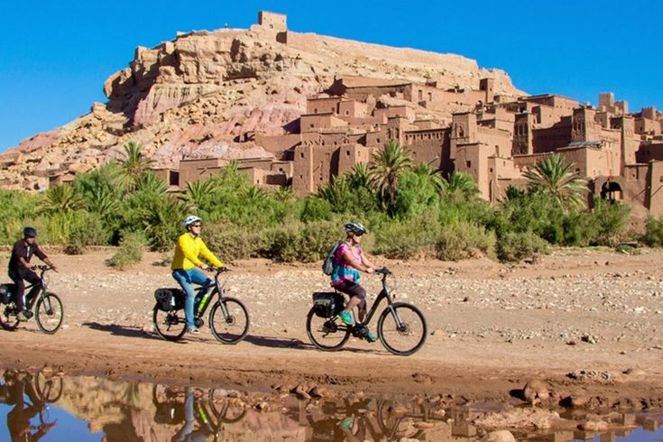 Drei Personen fahren Fahrrad durch eine orientalische Landschaft
