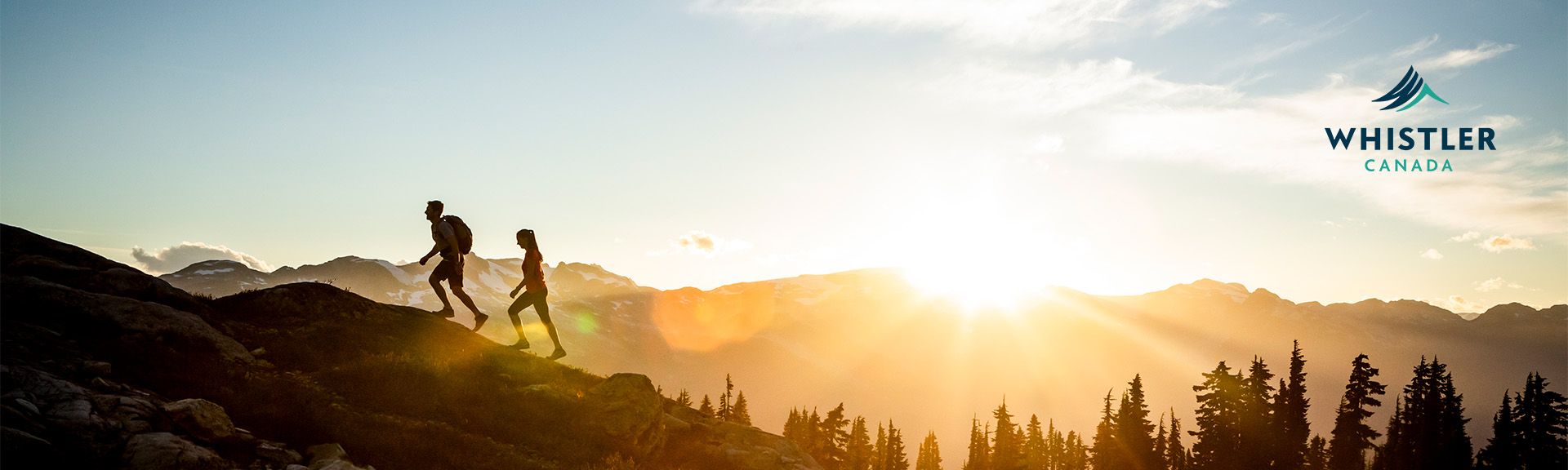 Zwei Personen steigen im Sonnenaufgang einen Berg hinauf