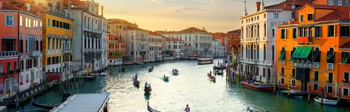 Eine Luftaufnahme von Venedig, Italien, mit Kanälen und Gebäuden bei Sonnenuntergang.