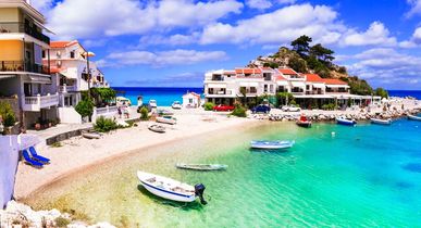 Eine Küstenstadt mit einem Strand und türkisfarbenem Wasser.