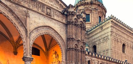 Ein historisches Gebäude mit einem Torbogen und einer Kathedrale.
