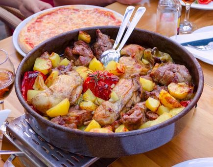 Eine gusseiserne Pfanne mit Peka (Fleisch- und Gemüsegericht).
