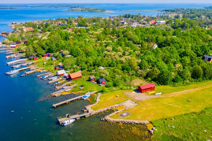 Blick aus der Vogelperspektivea auf Blekinge. Wald, Grünfläche, Steg mit Boot.