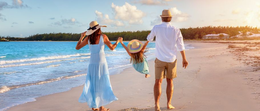 Paar läuft mit KInd am Strand