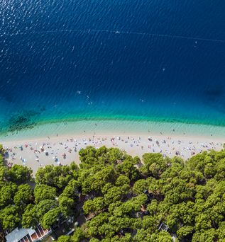 Eine Luftaufnahme eines Strandes mit türkisblauem Wasser.