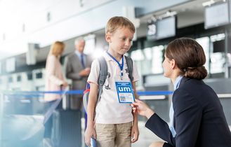 alleinreisender Junge mit Flugbegleiterin